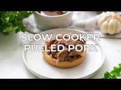 a slow cooker pulled pork sandwich on a white plate