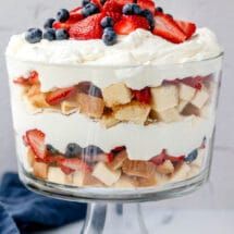 a trifle with strawberries, blueberries and other fruit on top in a glass dish