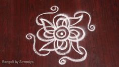 a white flower drawn on top of a wooden table