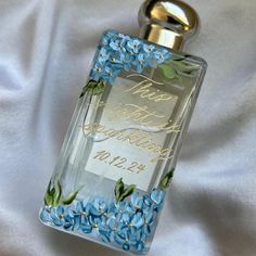 a bottle of perfume with blue flowers on it