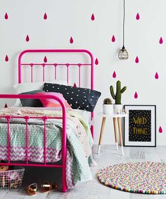 a pink bed frame in a bedroom with an umbrella wall sticker on the wall