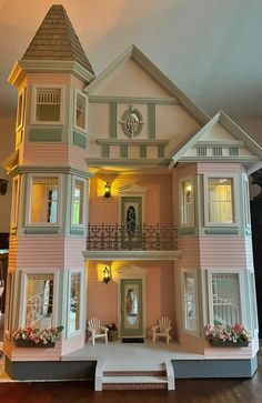 a doll house with furniture and decorations on the front porch is lit up at night