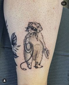 a tattoo on the leg of a person with a raccoon holding a computer mouse