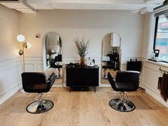 a hair salon with chairs and mirrors on the wall next to each other in front of a window