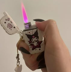 a person holding a lighter shaped like a cat with a key chain attached to it