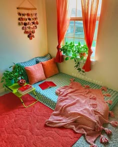 a bed with pillows and blankets on top of it in a room next to a window