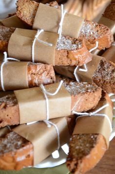 several pieces of bread wrapped in brown paper and tied with twine on a plate