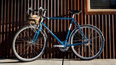 a blue bicycle parked next to a building