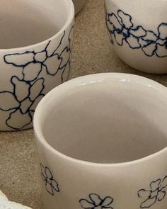 four white bowls with blue designs on them sitting on a counter top next to each other