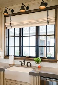 an image of a kitchen window with two lights above it and a sink in front of the window