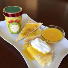 there is a piece of cake on the plate next to a jar of orange juice