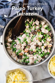 a pan filled with pasta, peas and chicken next to two bowls full of cheese