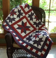 a chair with a quilt on it in front of a window