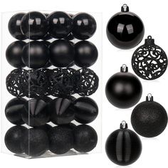 an assortment of black christmas ornaments in a clear display case, including baubles and balls