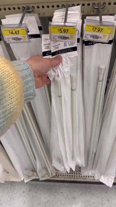 a person is picking up some white items from the shelf in a store or department