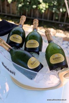 four bottles of champagne sitting in an ice bucket