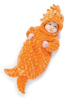 a baby in an orange animal costume laying on its back with his arms wrapped around the body