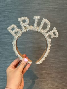 the bride tiara is being held by a woman's hand