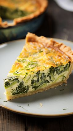 a slice of quiche with spinach and cheese on a plate