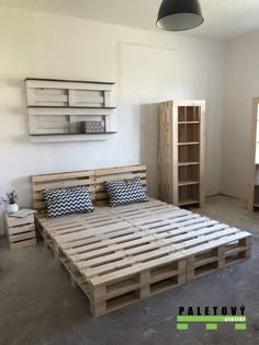 a bed made out of wooden pallets in a room with white walls and flooring