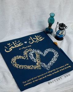 a blue book with arabic writing on it next to two vases and a lamp