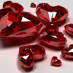 many red diamonds are scattered on a white surface, including one in the shape of a heart