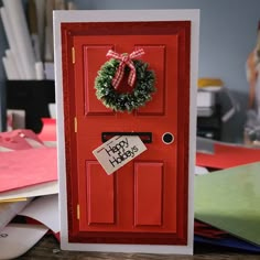 a red door with a happy holidays wreath on it and a sign that says happy holidays