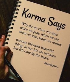 a hand holding a pen over a notebook with the words karma says written on it