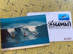 a postcard with an image of two surfers in the ocean on top of a wave