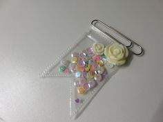 there is a paper clip with flowers on it and sequins in the middle