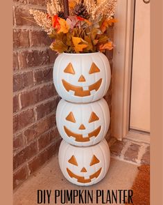 three pumpkins stacked on top of each other in front of a brick wall and door