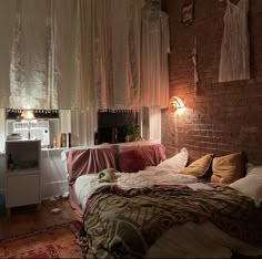 a bed room with a neatly made bed next to a brick wall and a window