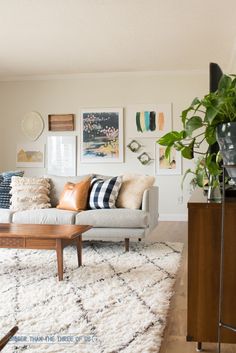 a living room filled with lots of furniture and pictures on the wall above it's coffee table