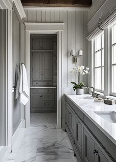 a large bathroom with two sinks and marble counter tops