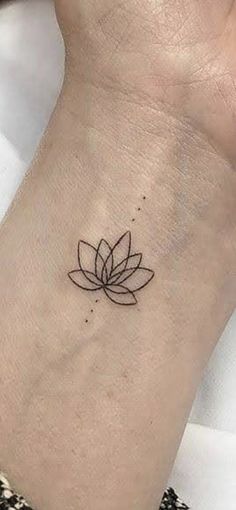 a small lotus tattoo on the wrist