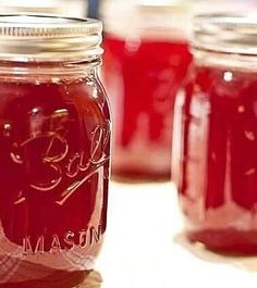 jars filled with red liquid sitting on top of a table