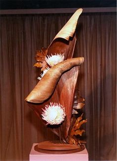 a sculpture made out of wood with flowers on it