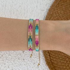 a woman's arm with two bracelets on it, one is pink and the other is blue