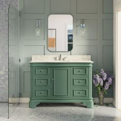 a bathroom with green cabinets and a white sink