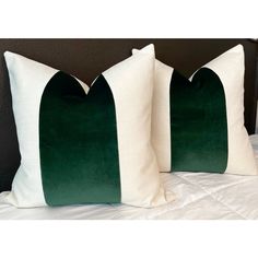 two green and white pillows sitting on top of a bed next to eachother