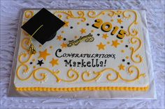 a graduation cake that is decorated with yellow and white icing, stars and the words congratulations mardela