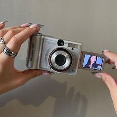 two hands are holding up a camera to take a picture with the same person on it