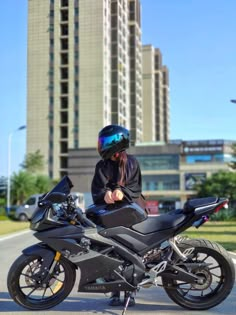 a person sitting on top of a black motorcycle