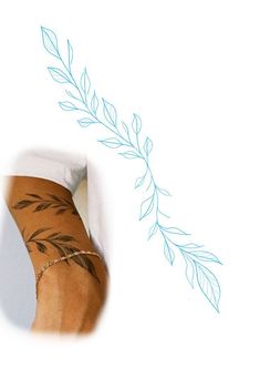 a woman's leg with tattoos on it and a branch drawn in the background