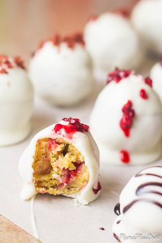 white chocolate covered desserts with cranberry toppings on a table next to each other