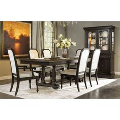 a dining room table with white chairs around it