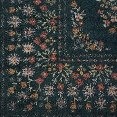 an area rug with flowers and leaves on the ground in front of a dark blue background