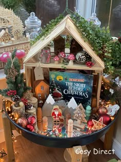 a christmas display in a store window with ornaments and decorations on the table, including a doll house