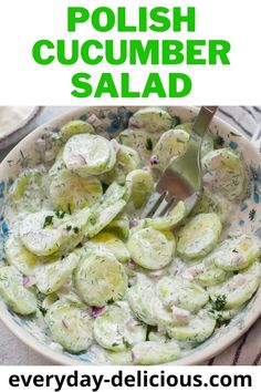 a bowl full of cucumber salad with a fork in it and the text overlay reads polish cucumber salad