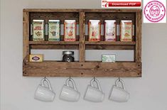 three mugs are hanging on a wooden shelf with tea cups and spices in them